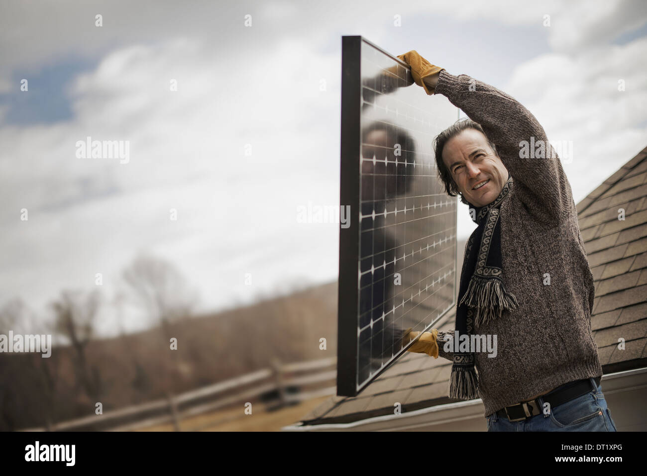 Ein Mann mit einem großen Solar-Panel über einen Hof Stockfoto