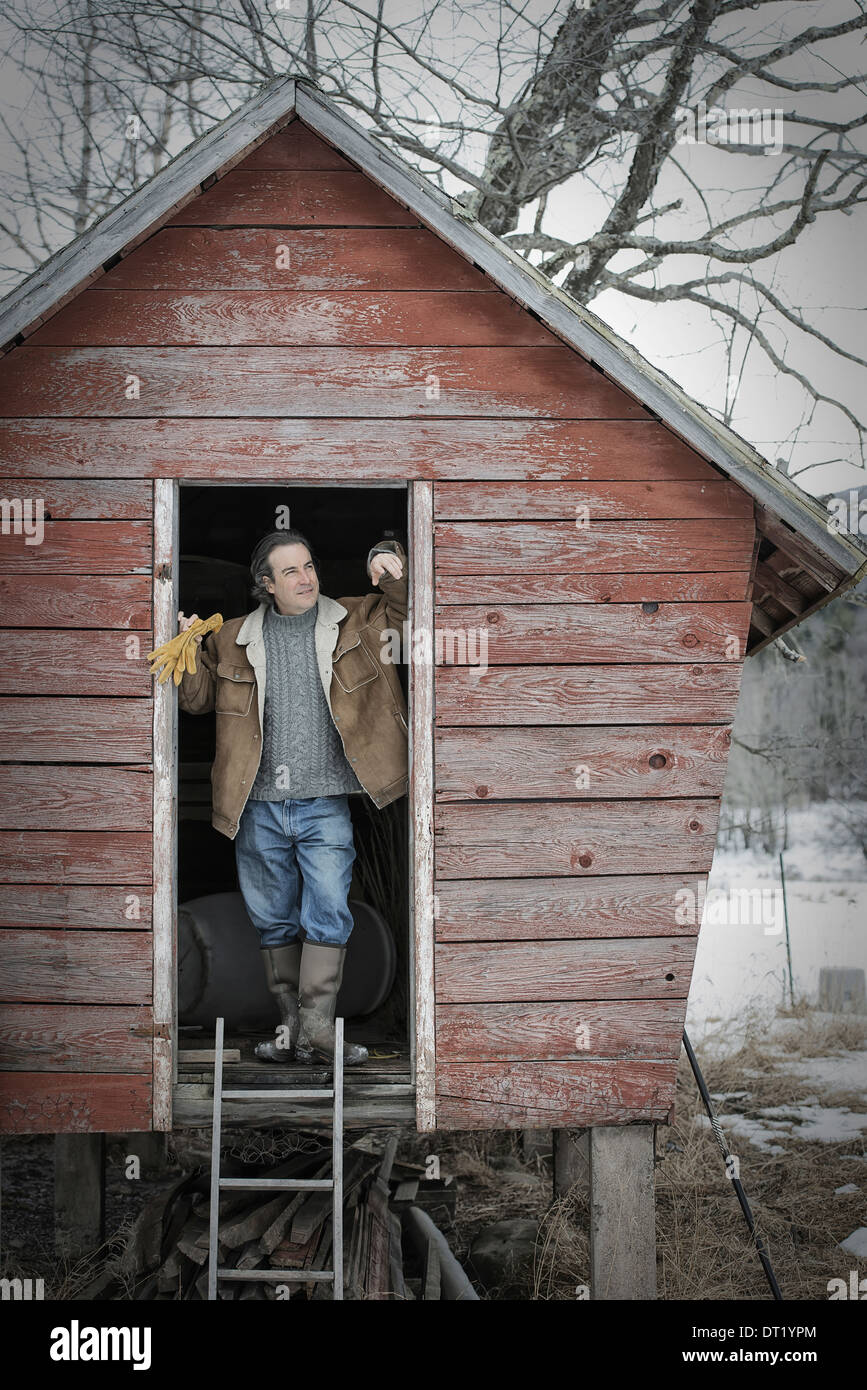 Ein Bio-Bauernhof im Bundesstaat New York im Winter A Mann stand in der Tür ein Hühnerstall Stockfoto