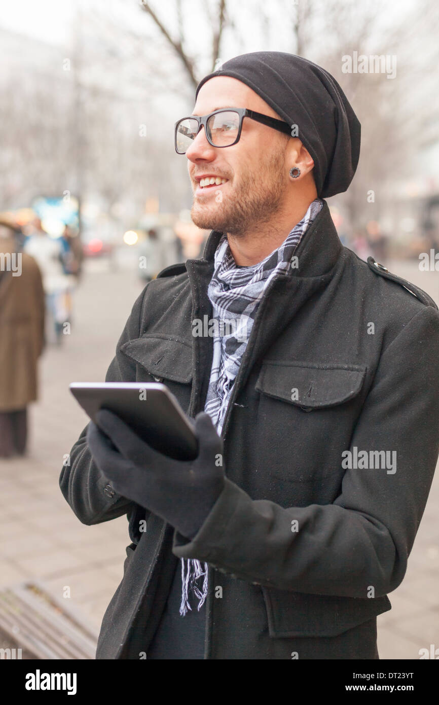 Junger Mann Lesen von Nachrichten und Informationen mit einem i-Pad Tablet-Computer. Stockfoto