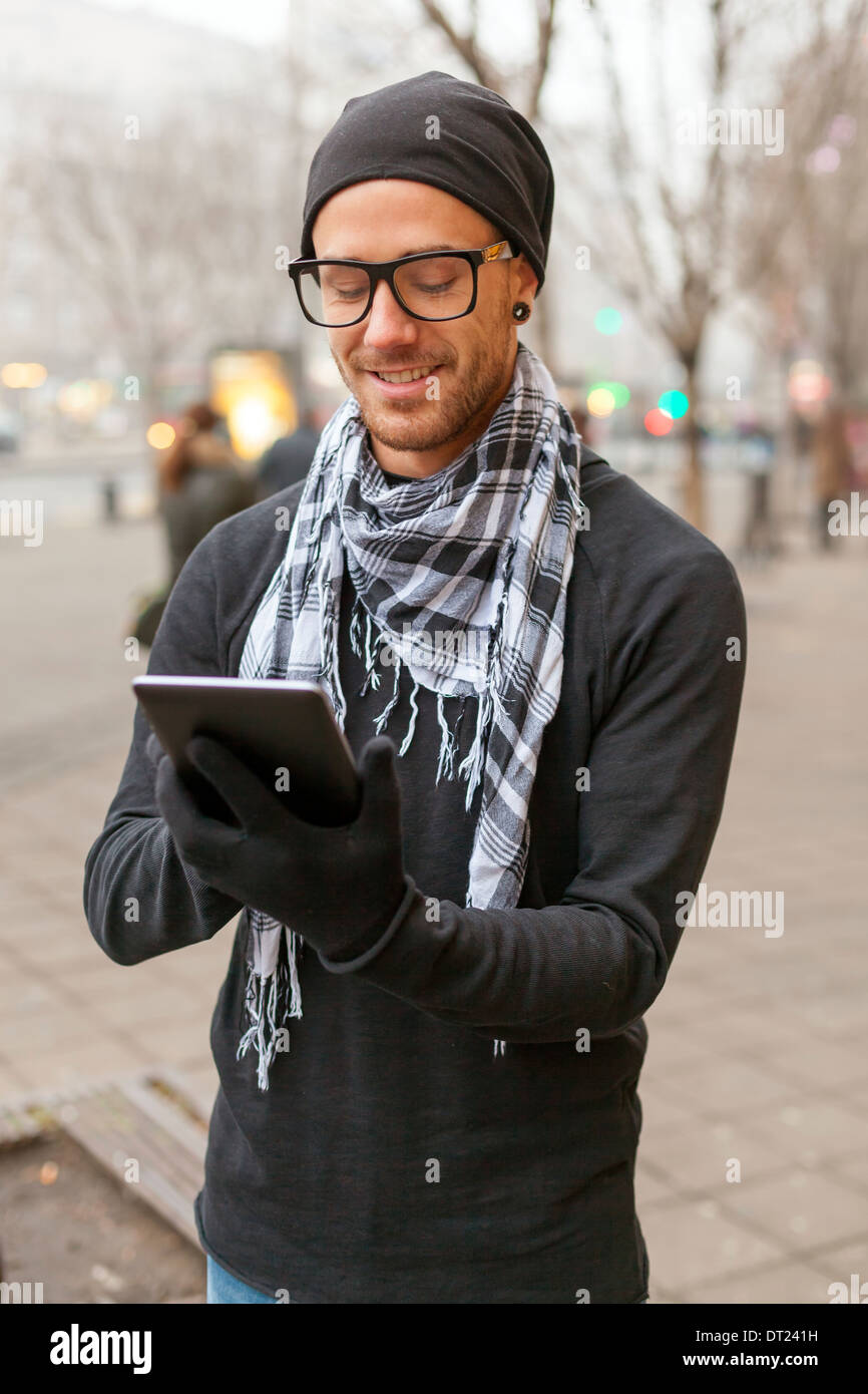 Junger Mann Lesen von Nachrichten und Informationen mit einem i-Pad Tablet-Computer. Stockfoto