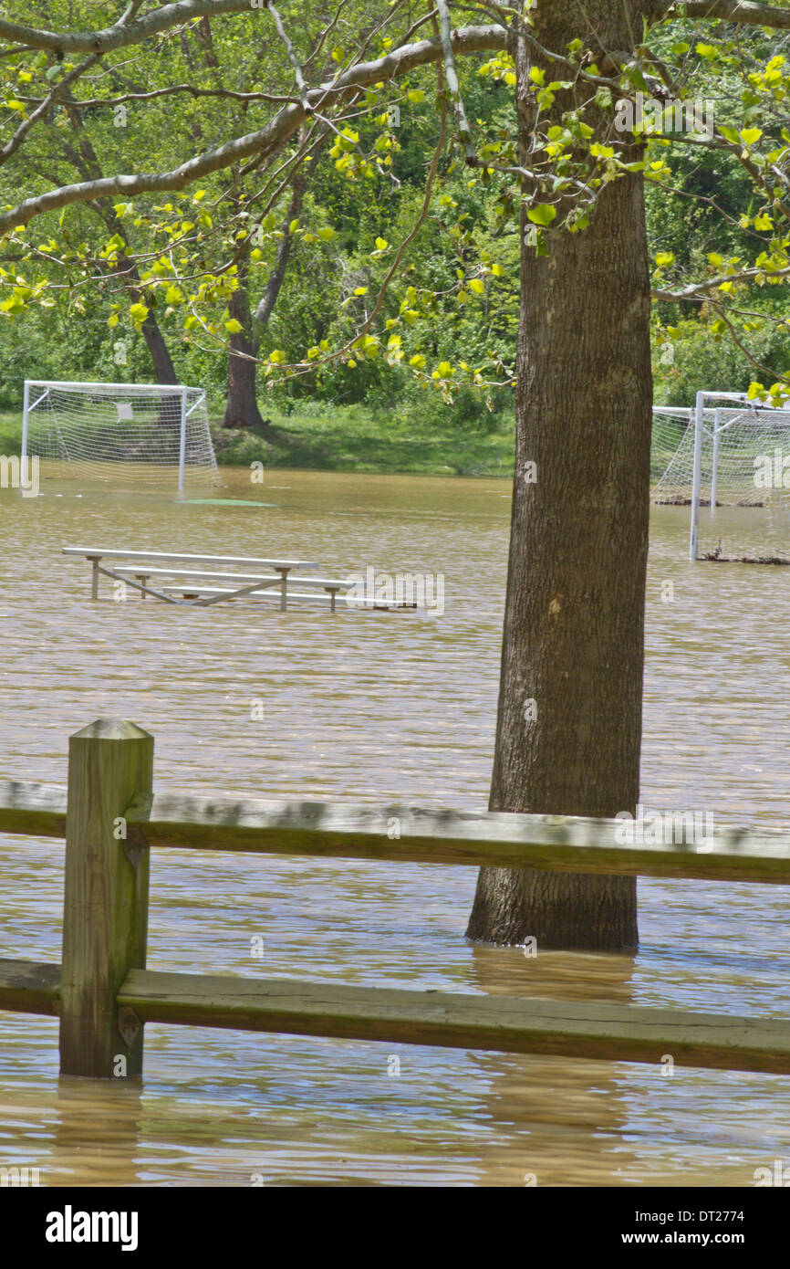 Ein Fußballfeld und Tornetze durch einen in der Nähe gelegenen Fluss im Frühjahr überschwemmten Stockfoto