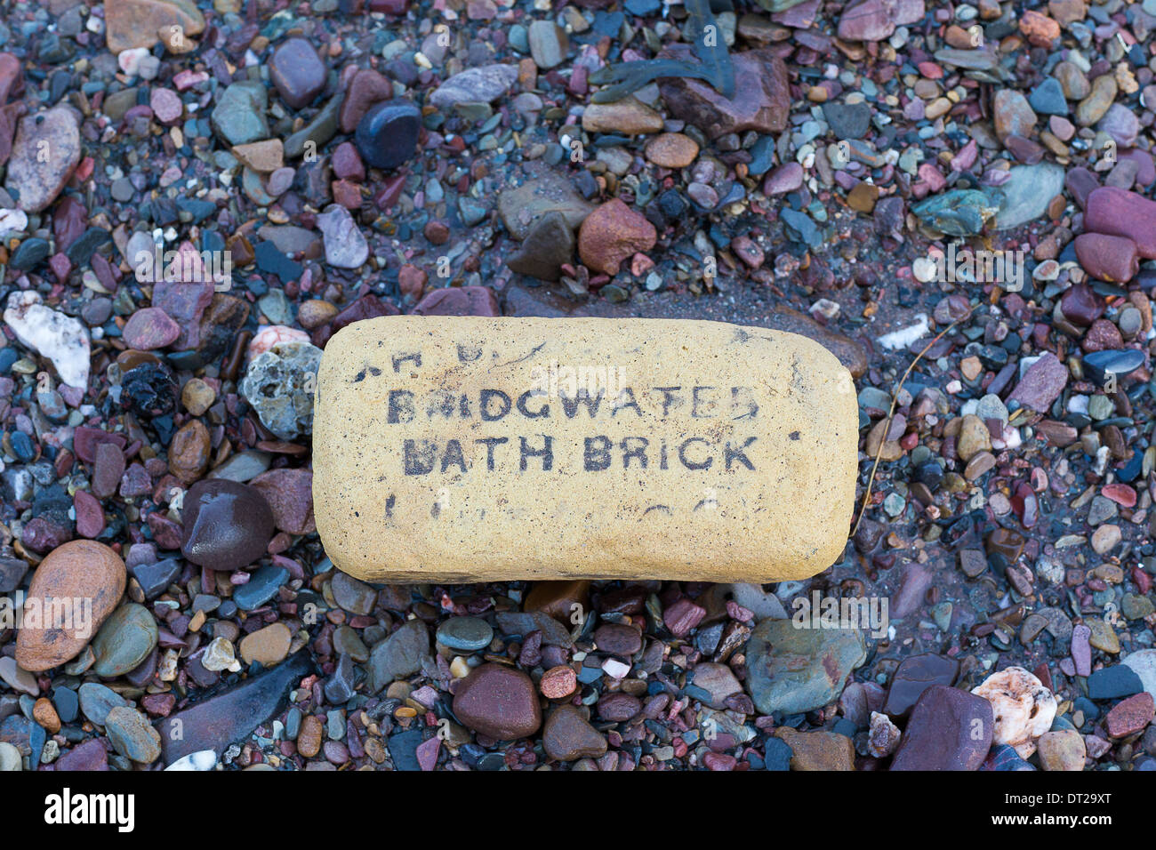 Eine alte Bridgwater Bad Ziegel am Strand von Doniford Bay in Somerset nach der Flut bei schweren Stürmen. Stockfoto