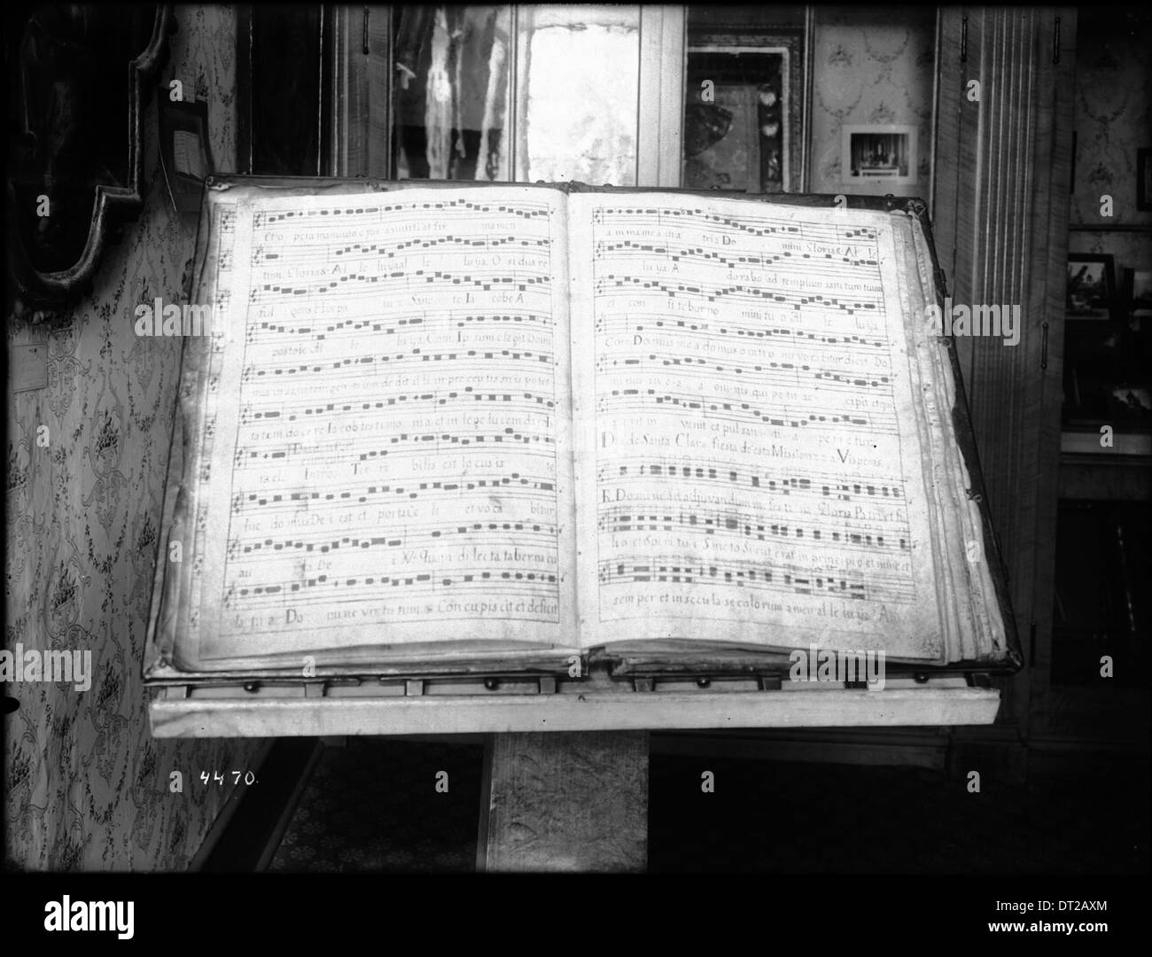Eine Fotografie eines großen Musikbuches wurde zu einem Hymnus mit dem Titel „A Vesper for the Feast of Santa Clara“ eröffnet, der sich in der Bibliothek der Mission Santa Barbara und Santa Clara Mission befindet, aufgenommen um 1905. Das Bild fängt die geistliche Musik in einem historischen Setting ein. Stockfoto