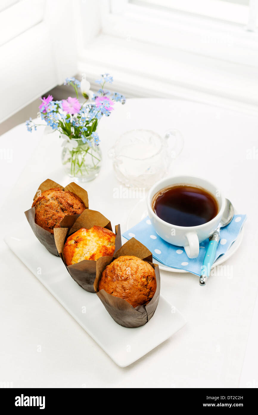 Drei Muffins und Kaffee am Frühstückstisch am Morgen Stockfoto