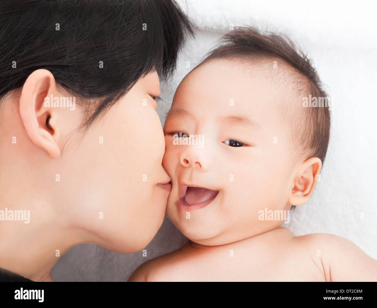 glückliche asiatische Mutter zu küssen, Tochter oder Sohn Stockfoto