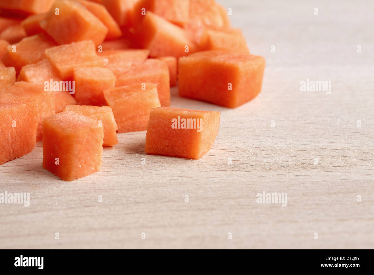 Gewürfelte rohe Karotten auf ein Schneidbrett aus Holz Stockfoto