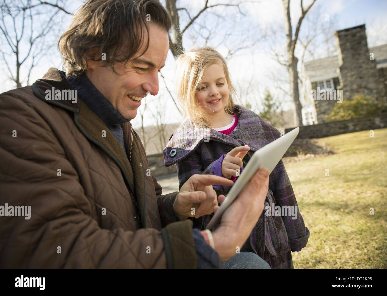 Ein Bio-Bauernhof im Winter im kalten Frühling New York State ein Mann mit einem digitalen Tablet in den Händen mit seinem Kind den Bildschirm Stockfoto