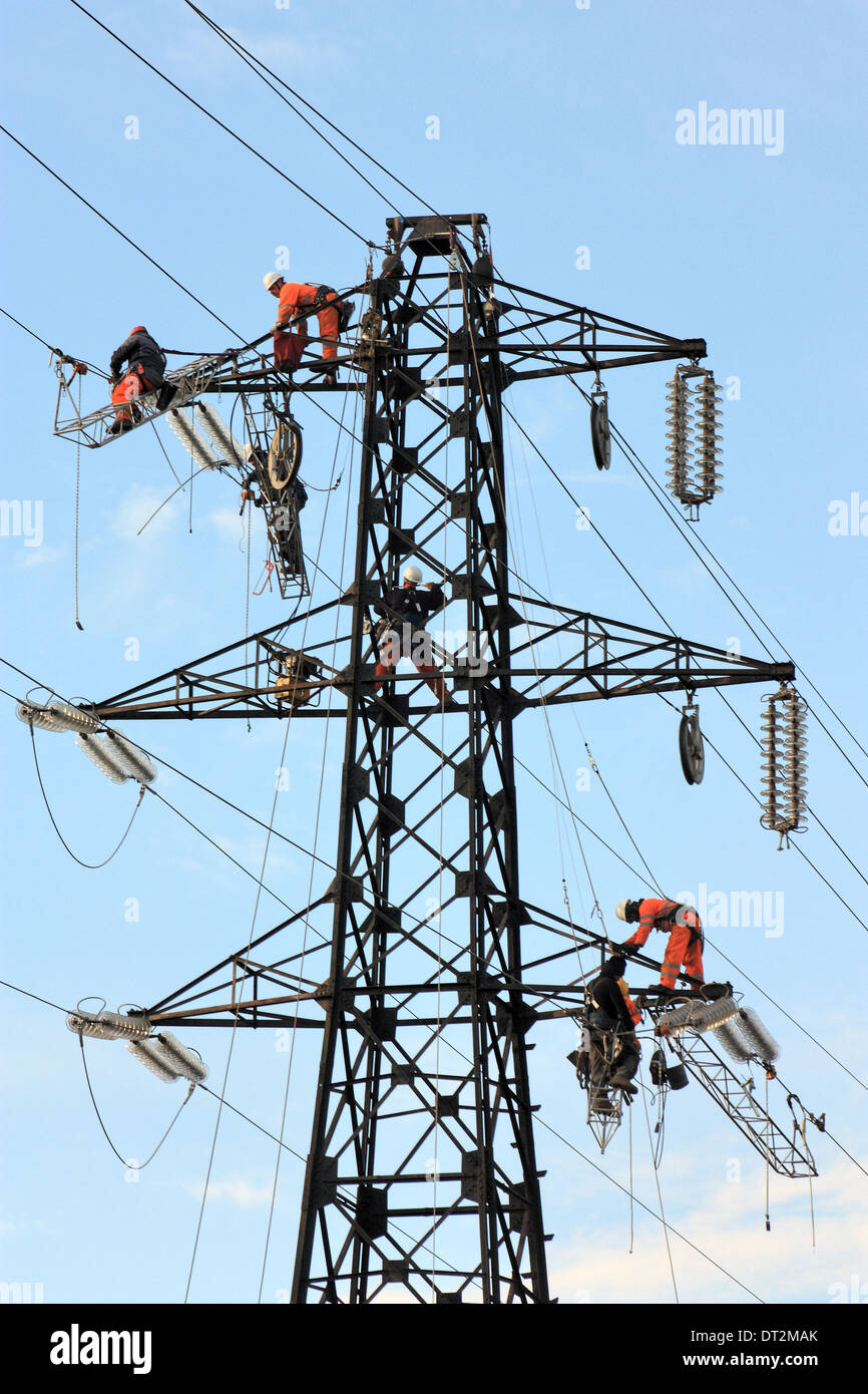 Arbeiter an Strommasten in Italien. Wartungsarbeiten von einer Hochspannungs-Leitung. Stockfoto