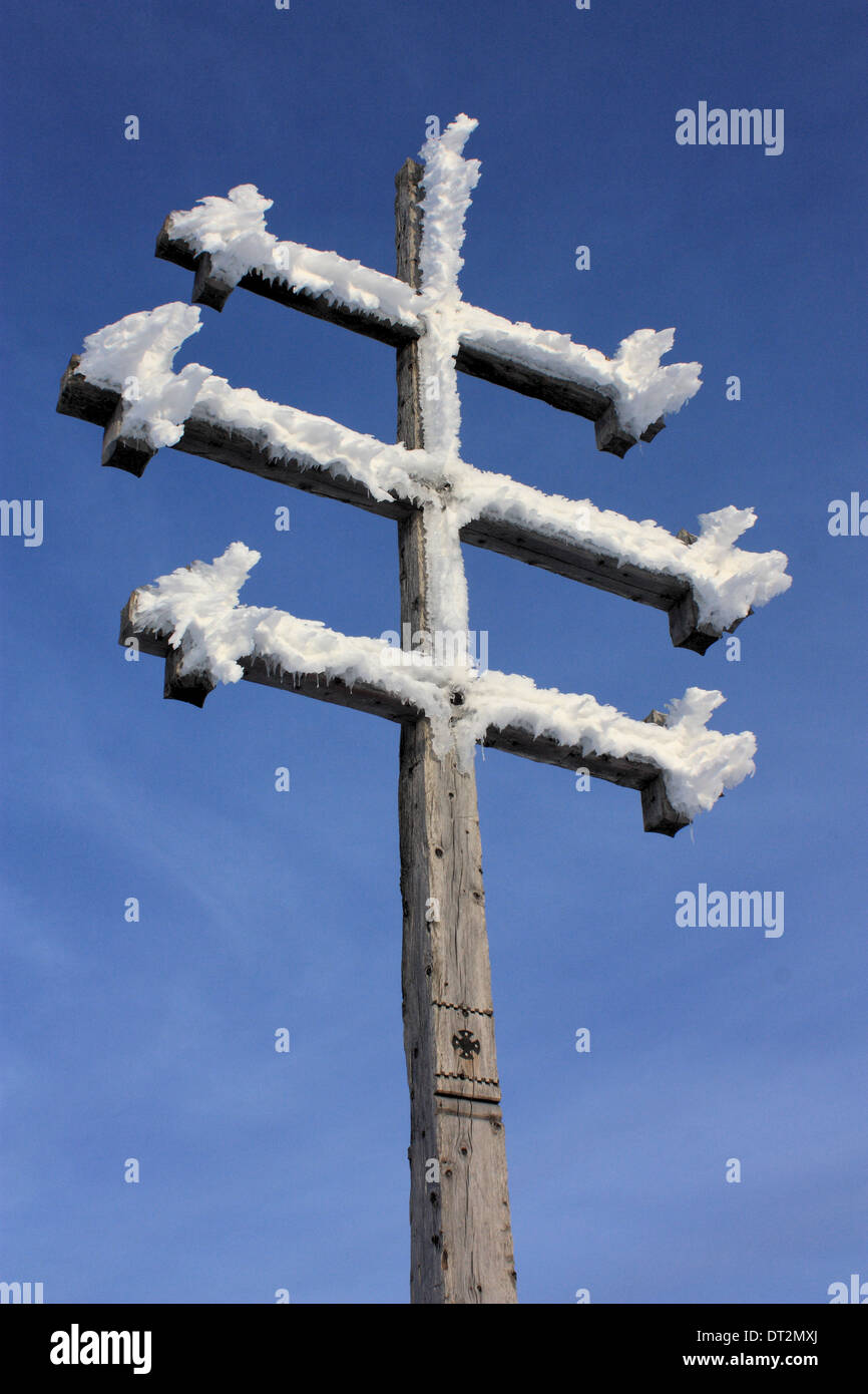 Gefrorene Gipfelkreuz auf einem Berg in den Dolomiten Stockfoto