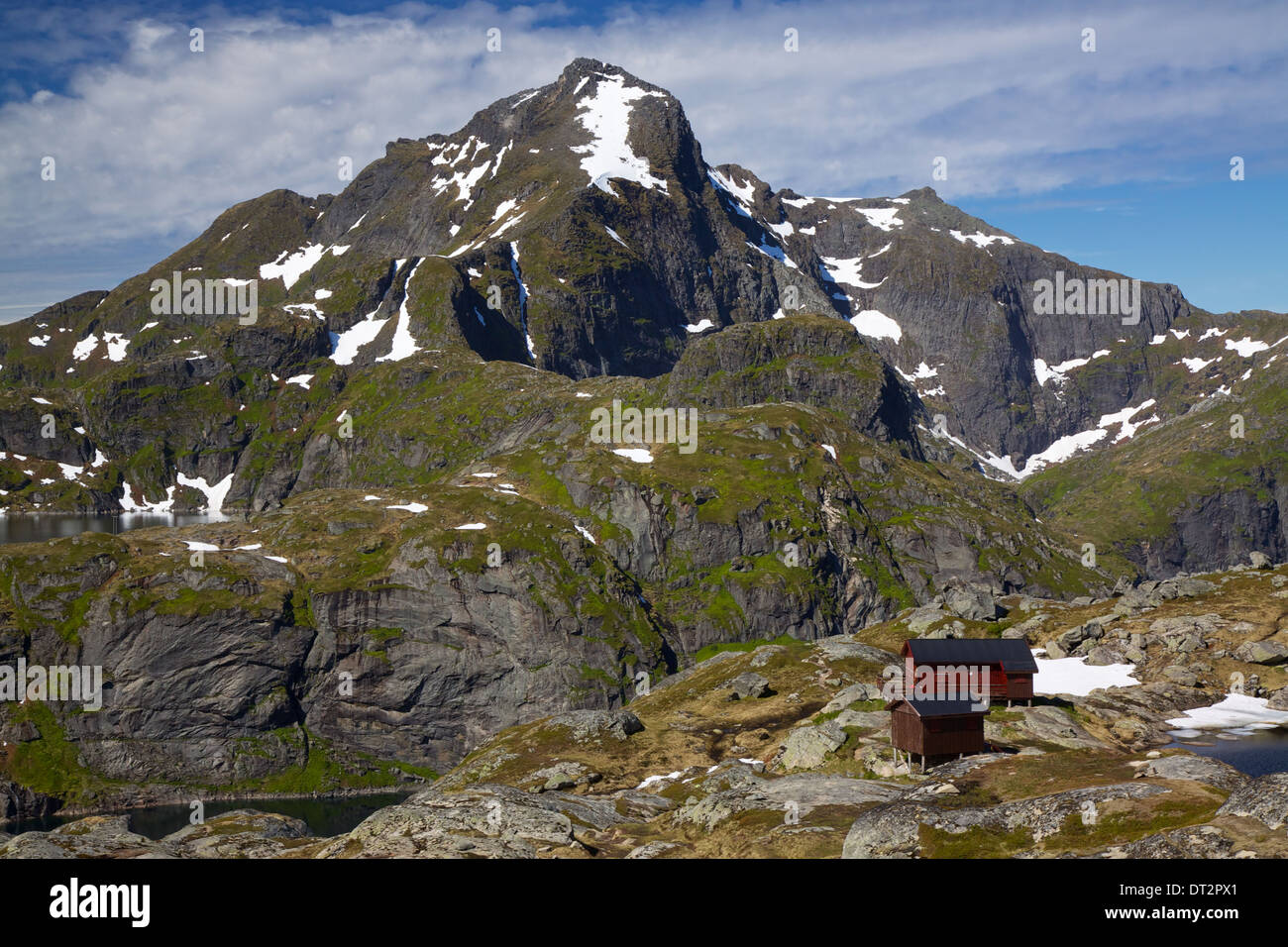 Malerische Hütte unterhalb des Berges Munkebu mit dem höchsten Gipfel im westlichen Lofoten, Hermannsdalstinden, im Hintergrund Stockfoto