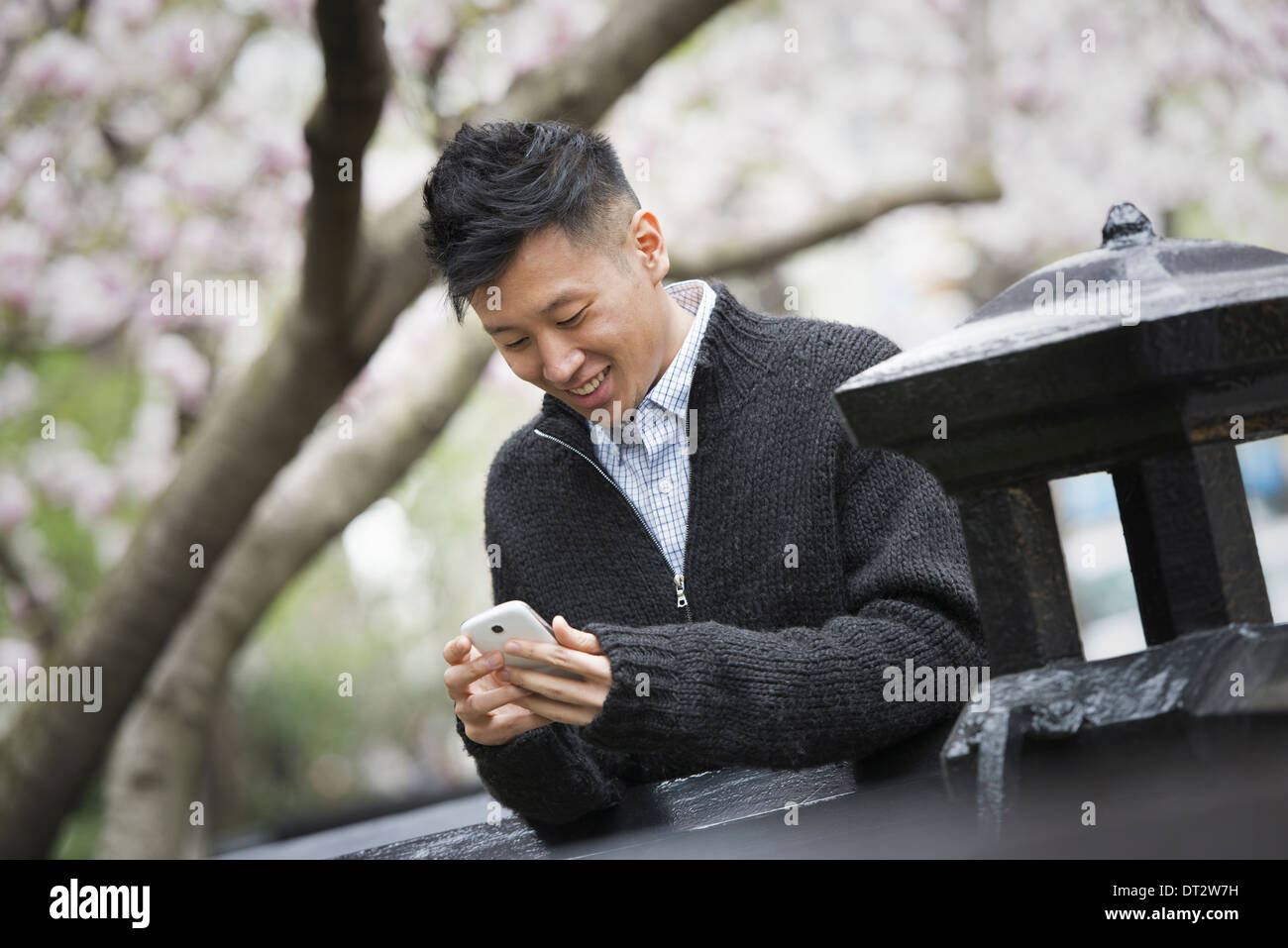 Blick über CityA junger Mann im Freien in einer Stadt park auf einer Bank sitzend Stockfoto