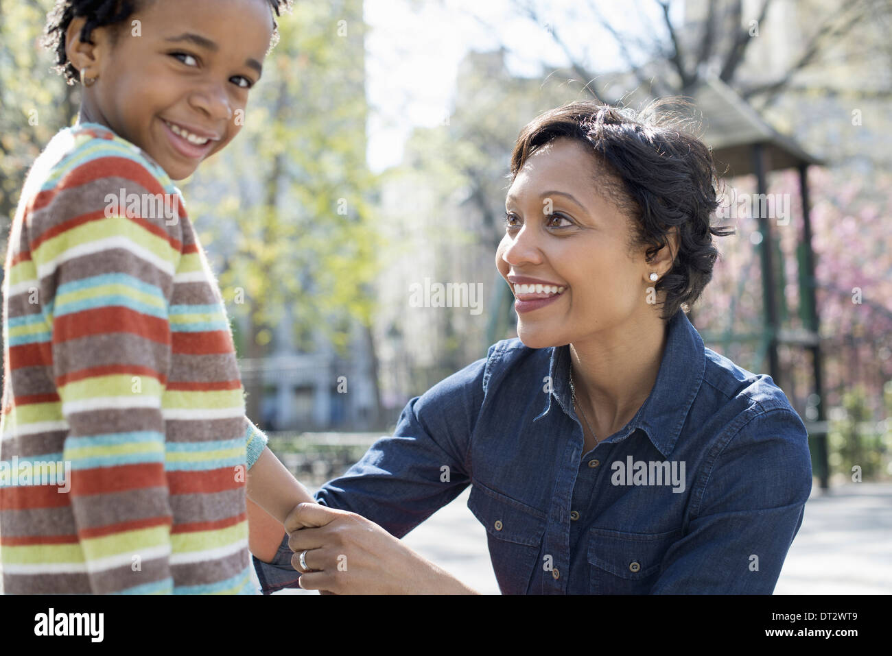 Sonnenschein und Kirschblüte A Mutter kniete lächelte ihren Sohn Stockfoto
