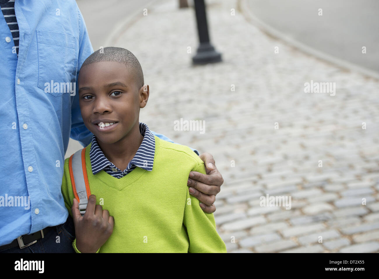 Ein Junge hält eine Tasche neben seinem Vater Stockfoto