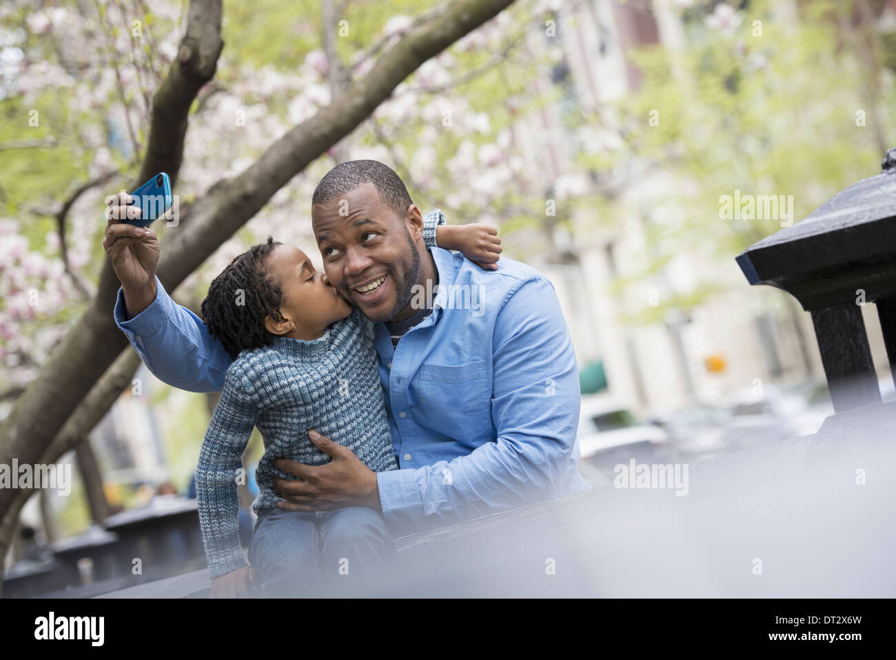 New York City Frühlingssonne und Kirschblüte A Vater und Sohn Seite an Seite mit einem Smartphone zu fotografieren Stockfoto
