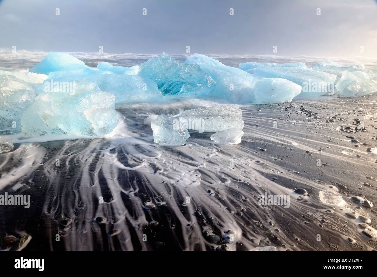 Eisberge und Wellen am Jökulsárlón Strand, Polarregion, Südisland Stockfoto