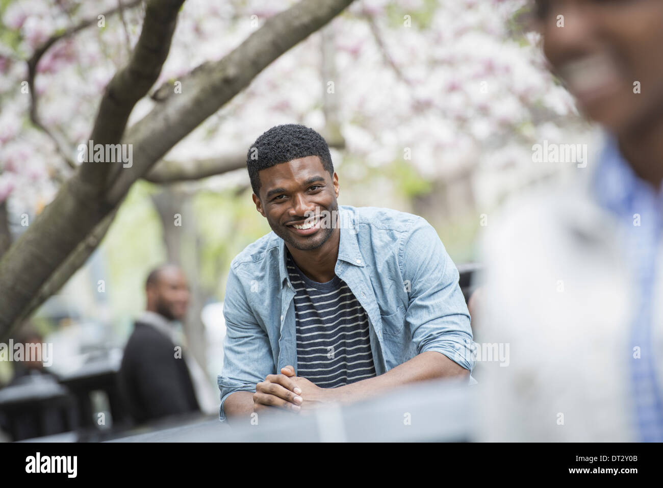 Ein Mann sitzt an einem Tisch Lächeln einer Frau im Vordergrund Stockfoto