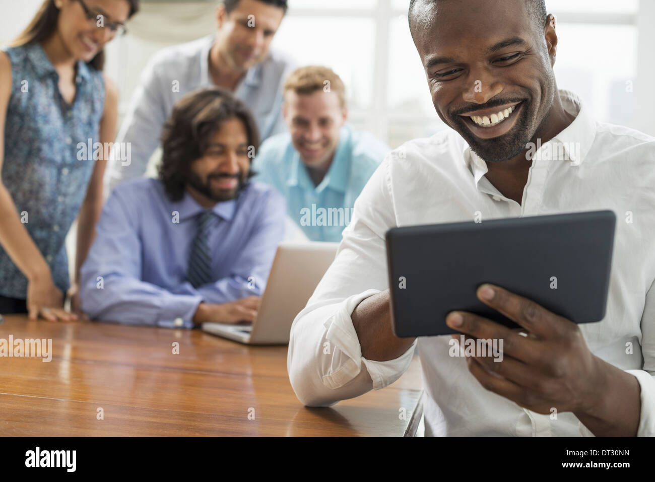 Business-Leute versammelten sich in einem Büro in der Stadt ein Team von fünf Menschen-Männer und Frauen sammeln sich um einen laptop Stockfoto