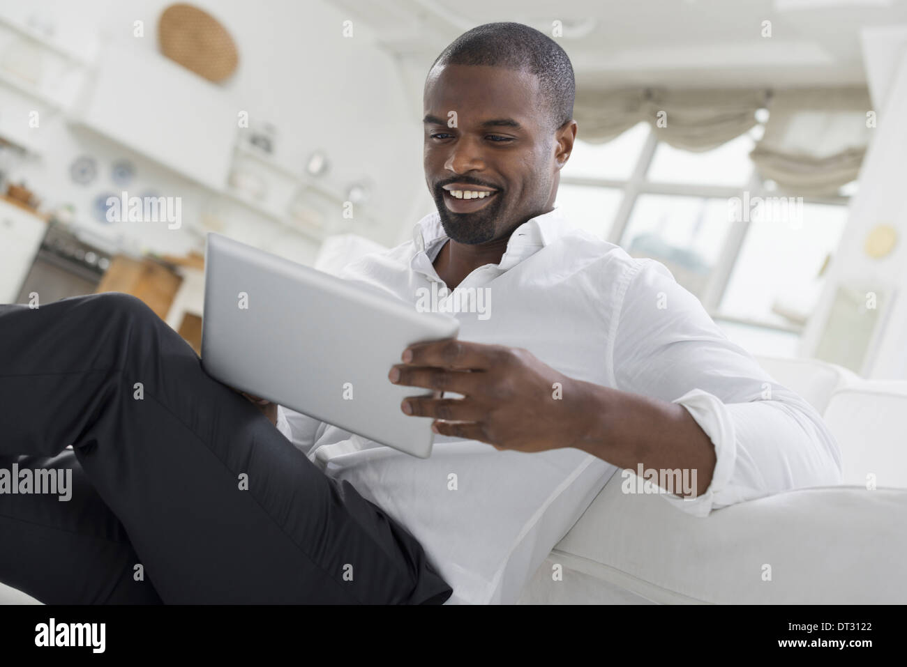 Eine Person sitzt bequem in einer ruhigen luftig Büroumgebung mit einem digitalen tablet Stockfoto