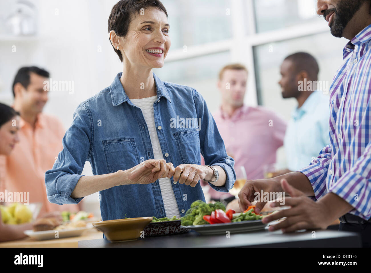 Ein offenes Büro A Arbeitsessen planen ein Salatbuffet altersgemischte und Ethnien treffen zusammen Stockfoto