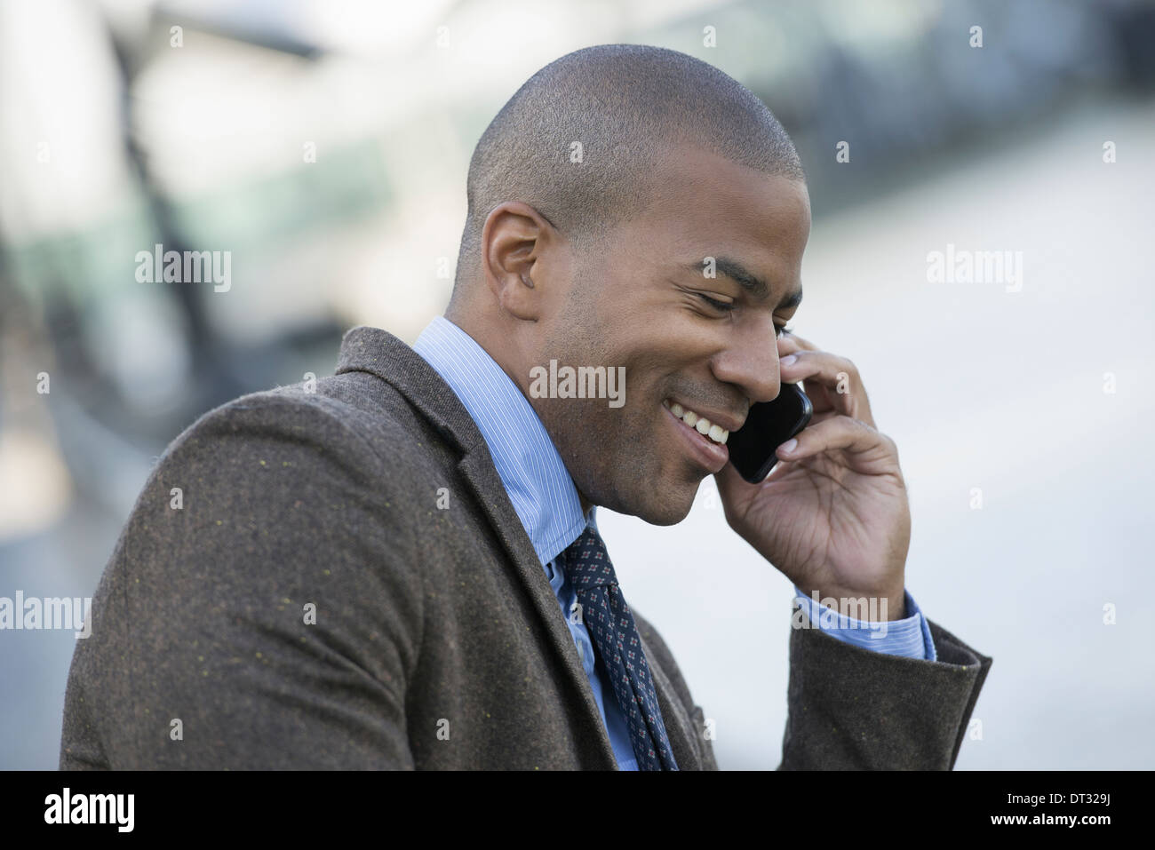 Ein Mann sitzt auf einer Bank tätigen eines Anrufs auf seinem Smartphone Stockfoto