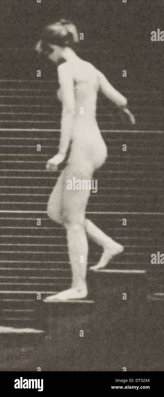 Ein Foto einer nackten Frau, die eine Treppe hinabsteigt und die Form und Bewegung des Motivs in einem Vintage-Ambiente betont. Stockfoto