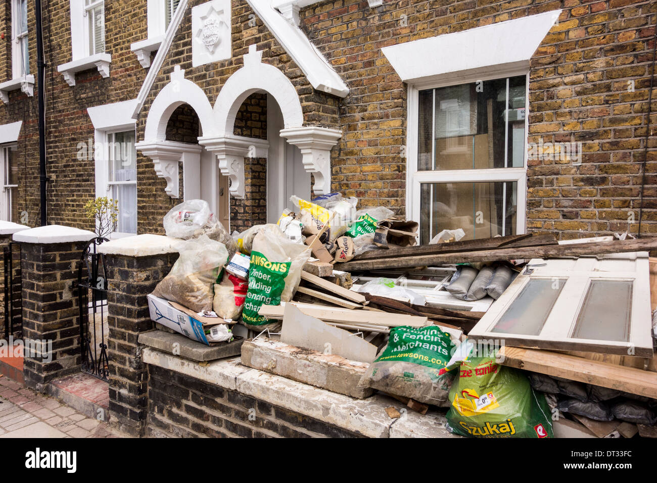 Des Erbauers Müll stapelten sich außerhalb eines Hauses bei Haus Renovierung, London, UK Stockfoto