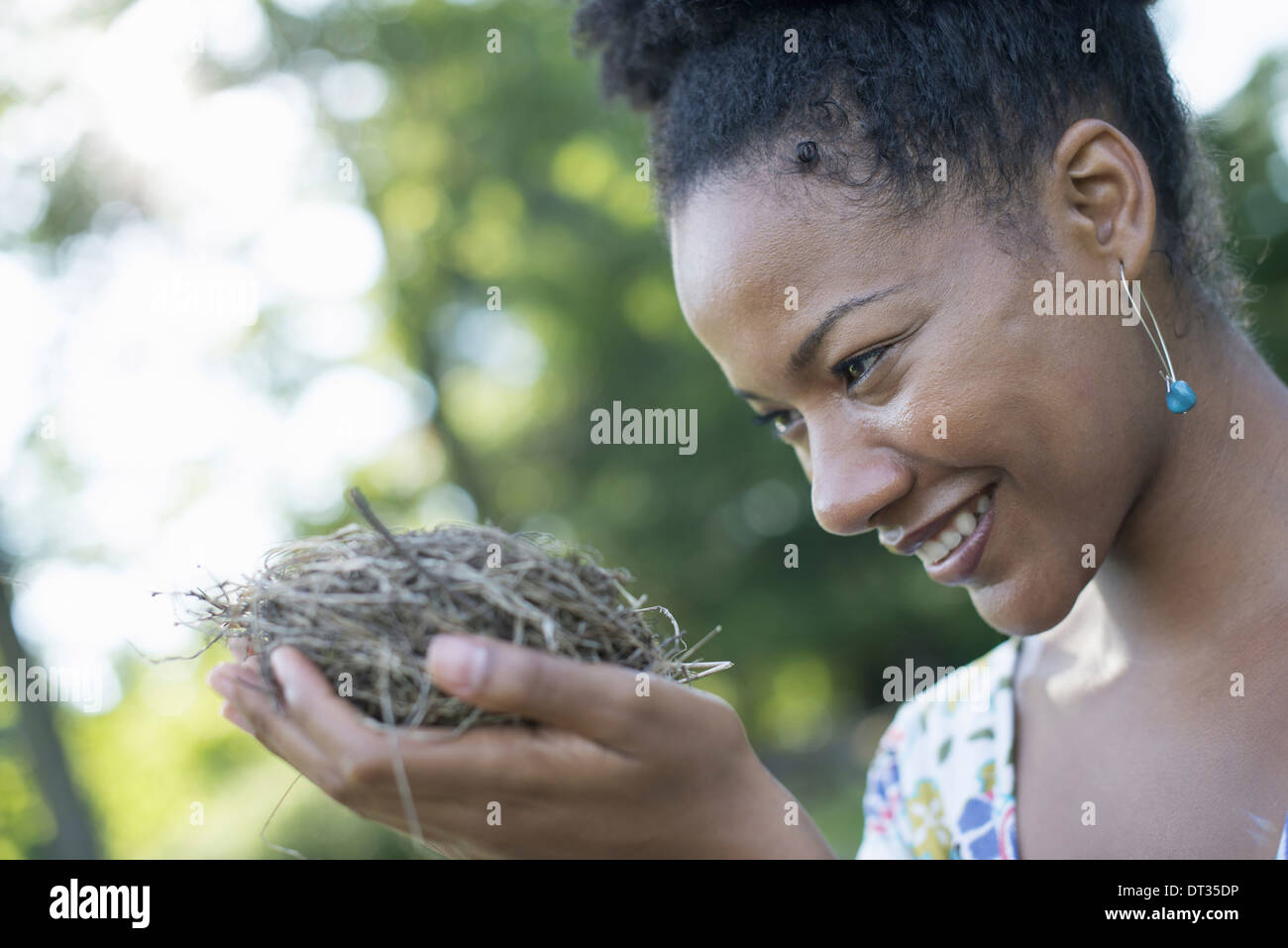 Eine Frau hält ein Vogelnest in ihren Händen Stockfoto