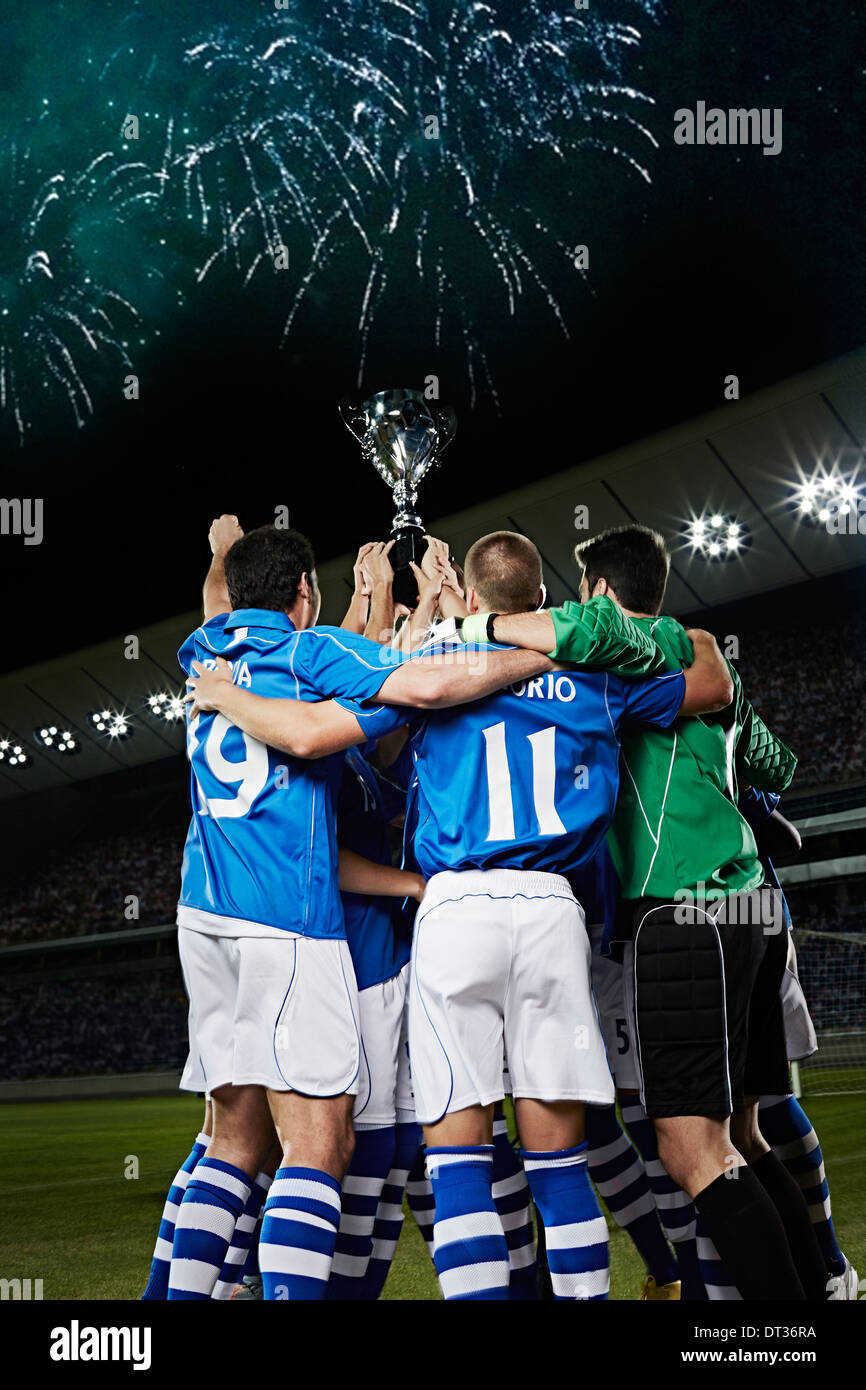 Fußball-Team jubeln mit Trophäe auf Feld Stockfoto