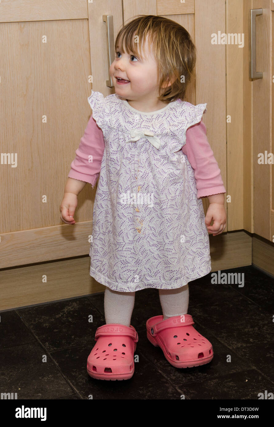 18 Monate altes Mädchen Mutter Crocks Schuhe tragen. Stockfoto