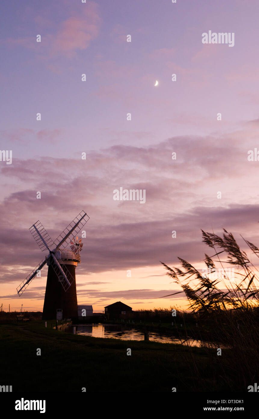 Horsey Windpumpe, Norfolk, Großbritannien. Dezember. Sonnenuntergang mit neueres Mond Stockfoto