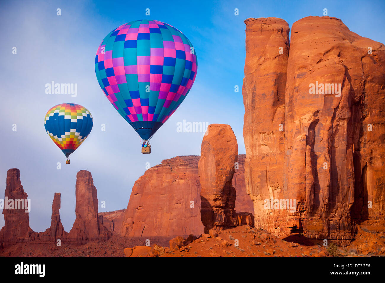 Heißluftballons treiben vorbei an den drei Schwestern und den Daumen Felsformationen, Monument Valley Navajo Tribal Park, Arizona USA Stockfoto