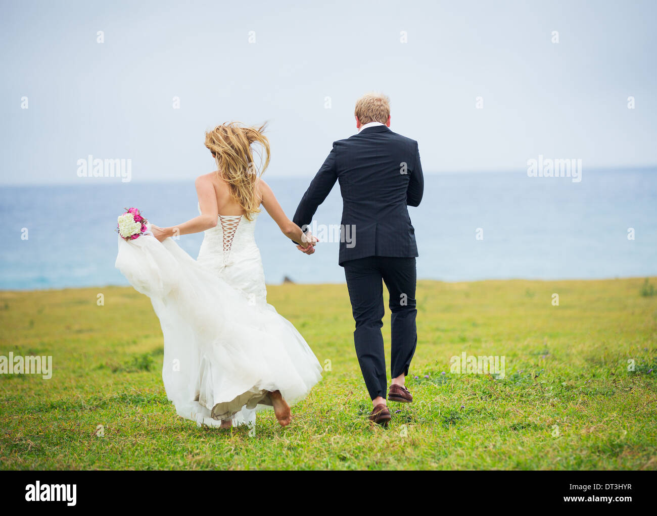Hochzeitspaar, glücklich romantische Braut und Bräutigam in der Liebe läuft durch Feld Stockfoto