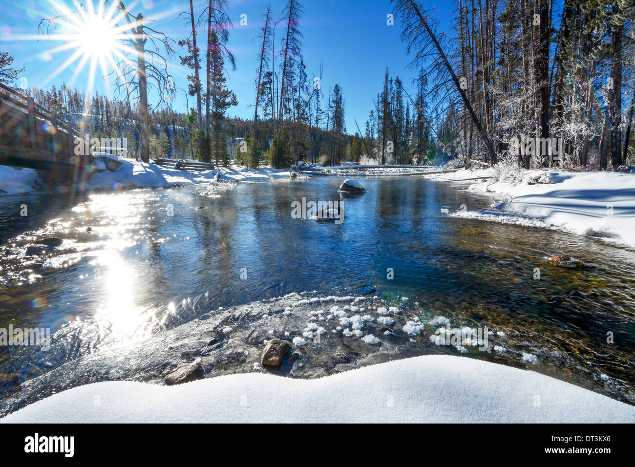 Sunstar und wilden Fluss im Winter mit Brücke Stockfoto