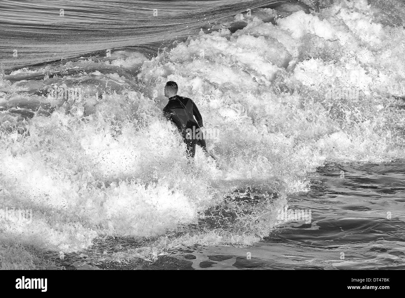 Schwarz-weiß-Foto Eines Mannes, der am Hermosa Beach, Los Angeles, Kalifornien, USA surft Stockfoto