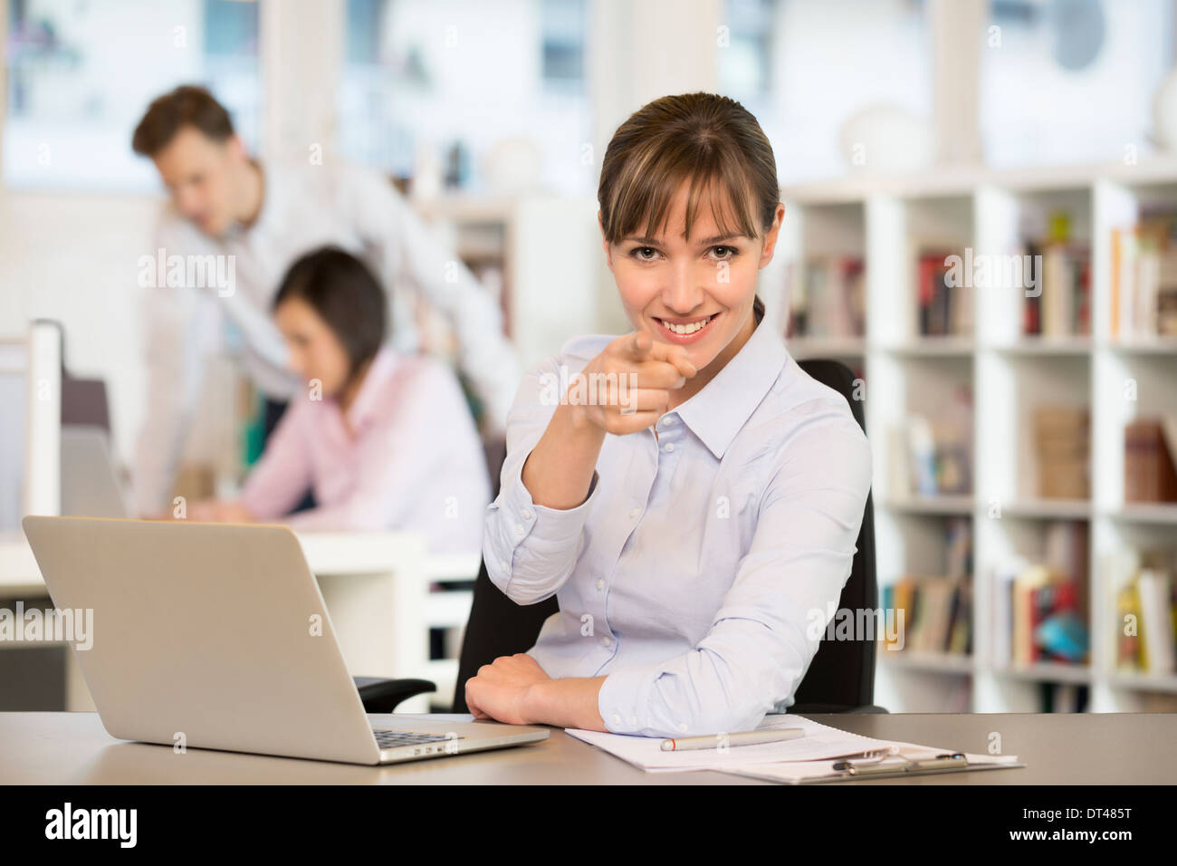 Glückliche Frau Schreibtisch lächelnd Punkt Finger computer Stockfoto