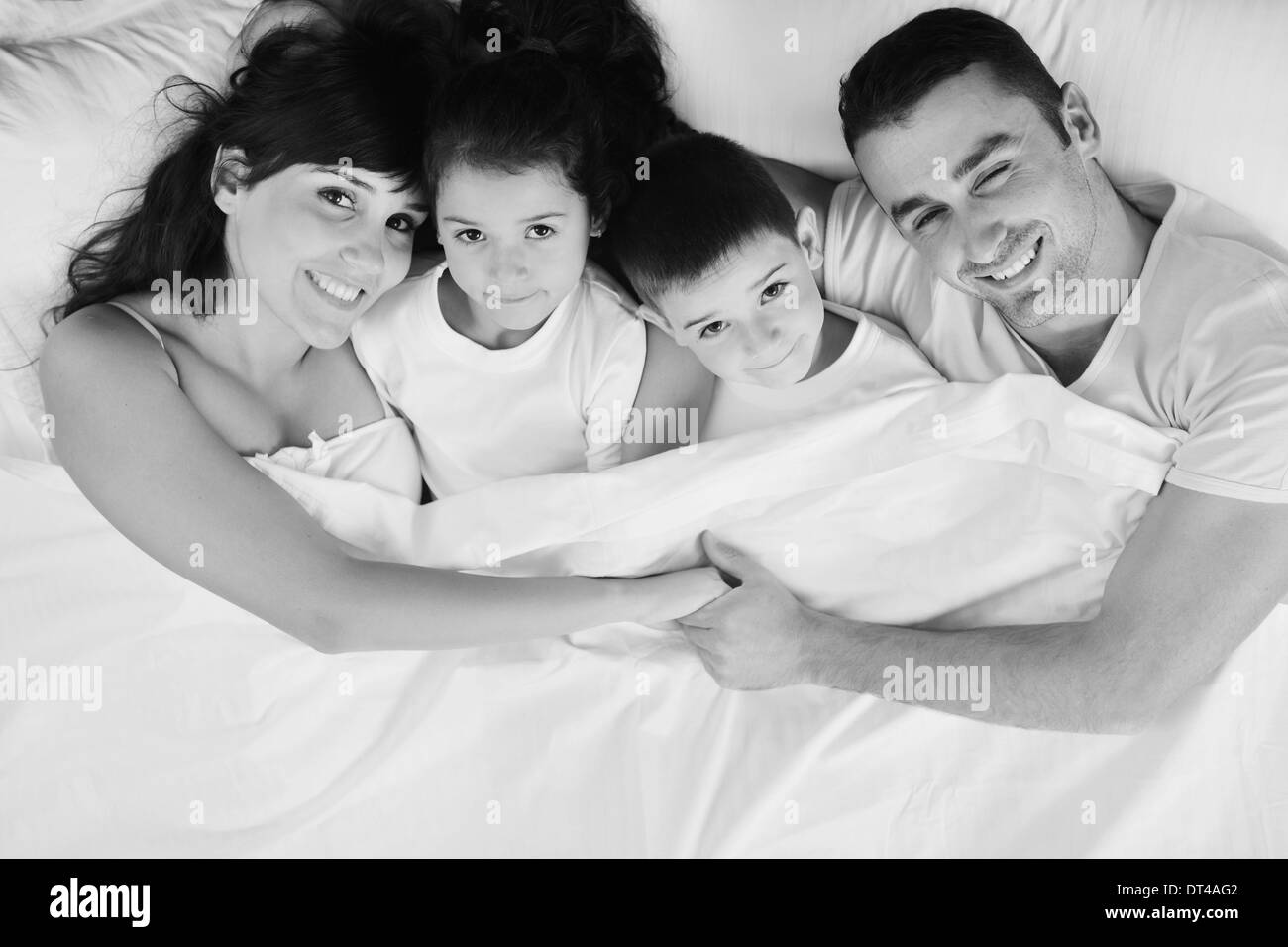 glückliche junge Familie in ihrem Schlafzimmer Stockfoto