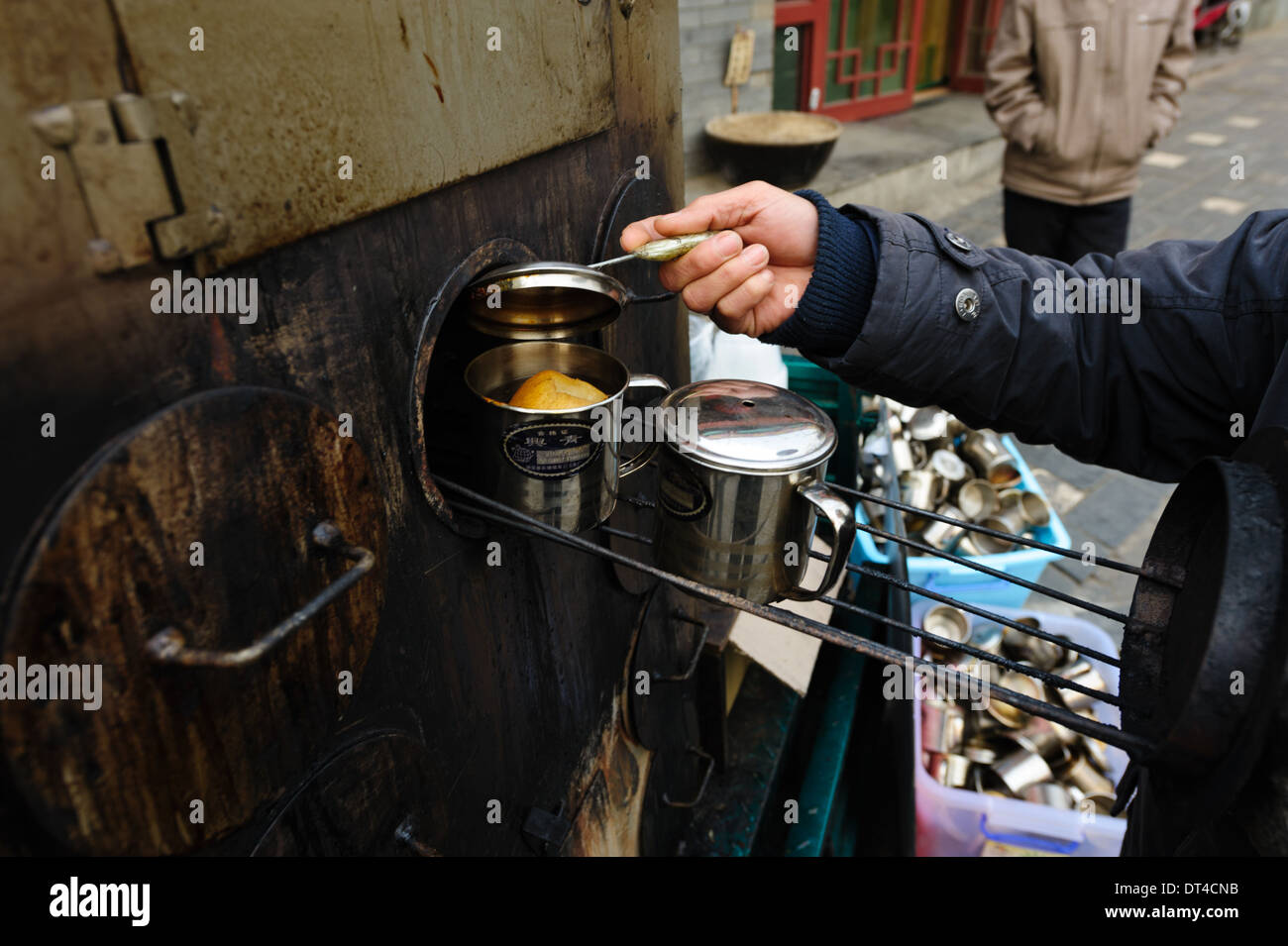 Man bereitet einen warmen Snack in einem mobilen Ofen. Peking, China Stockfoto