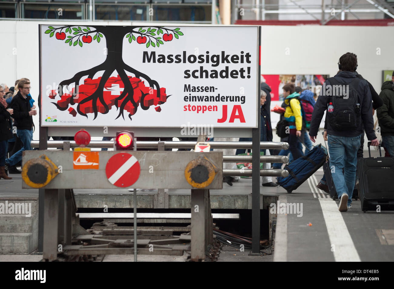 Zürich, 8. Februar 2014: ein Referendum campaign Poster von rechtsradikalen Partei SVP ", Masseneinwanderung stoppen" am Ende einer Eisenbahnstrecke im Zürcher Hauptbahnhof einen Tag vor den Plebisziten stattfindet. Das kommende Schweizer Referendum feste Quoten auf Zuwanderung aus EU-Ländern und macht (wenn von den Schweizern angenommen) setzen Sie ein Ende, die bestehenden bilateralen Treatys mit den EU.ns wieder eingeführt werden soll. Bildnachweis: Erik Tham/Alamy Live-Nachrichten Stockfoto