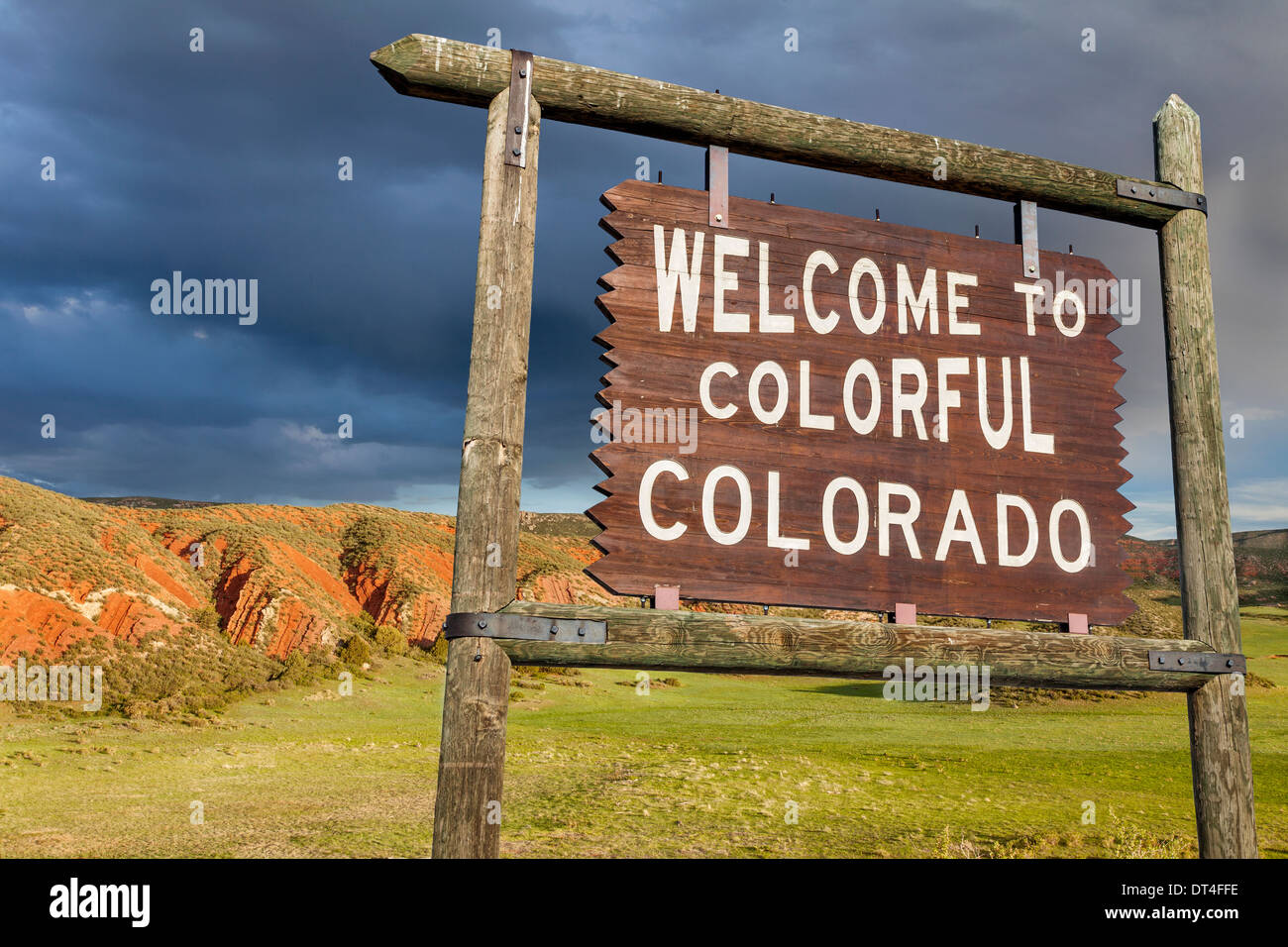 Willkommen Sie bei bunte Colorado am Straßenrand Holzschild mit rotem Sandstein Felsen im Hintergrund Stockfoto
