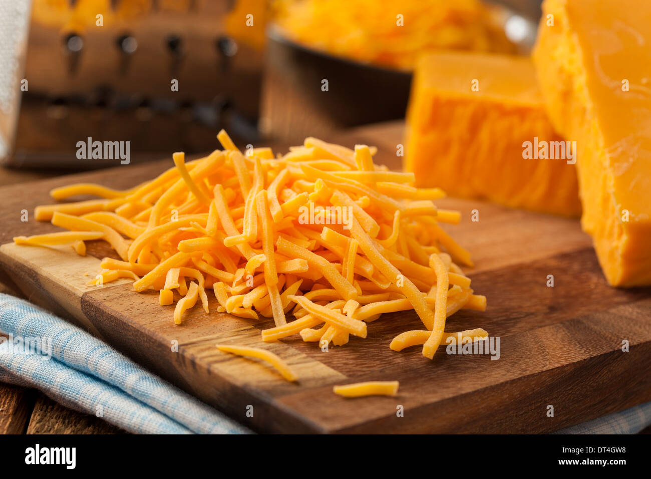 Bio geschreddert scharfe Cheddar-Käse auf ein Schneidebrett Stockfoto