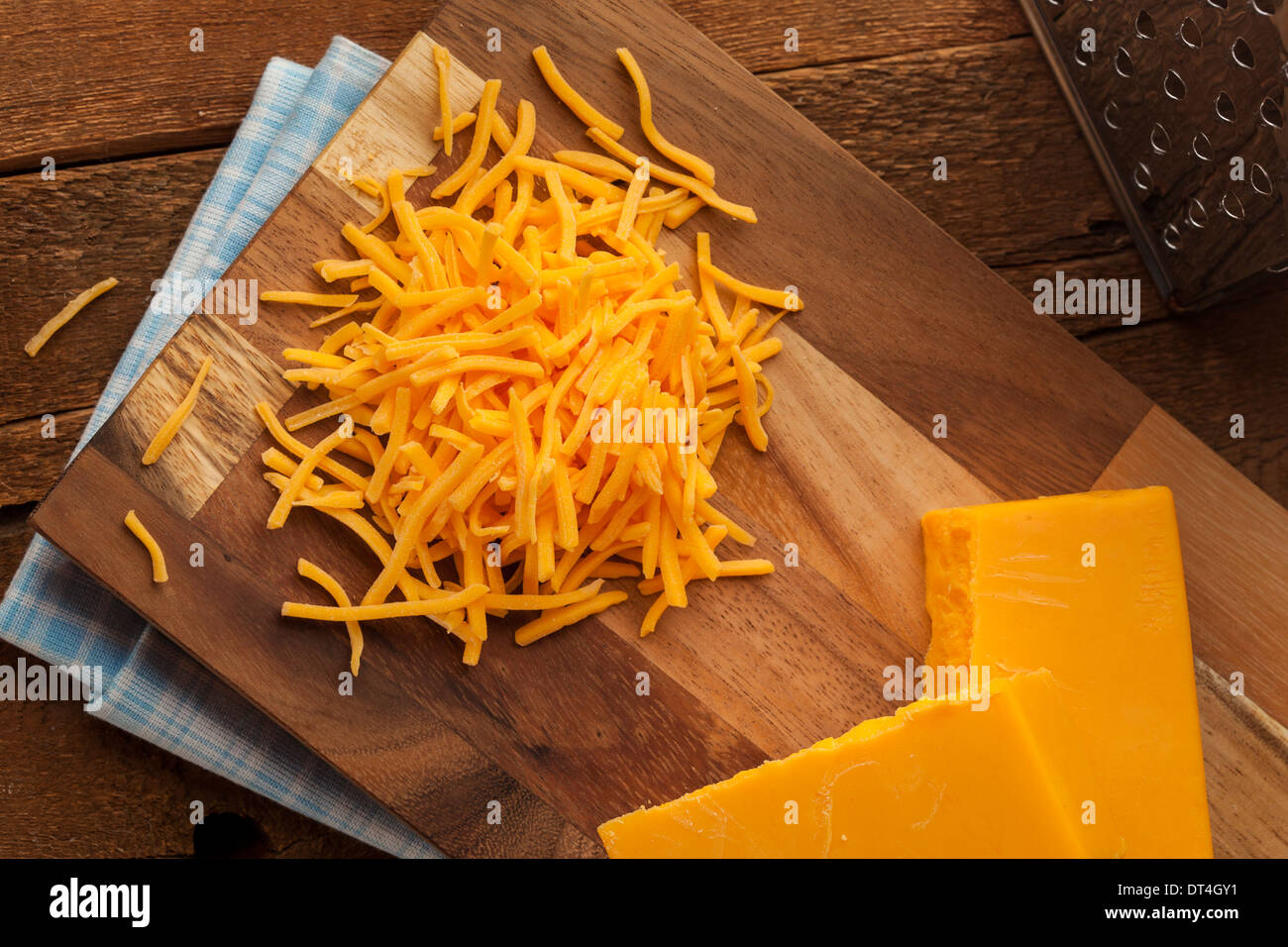 Bio geschreddert scharfe Cheddar-Käse auf ein Schneidebrett Stockfoto