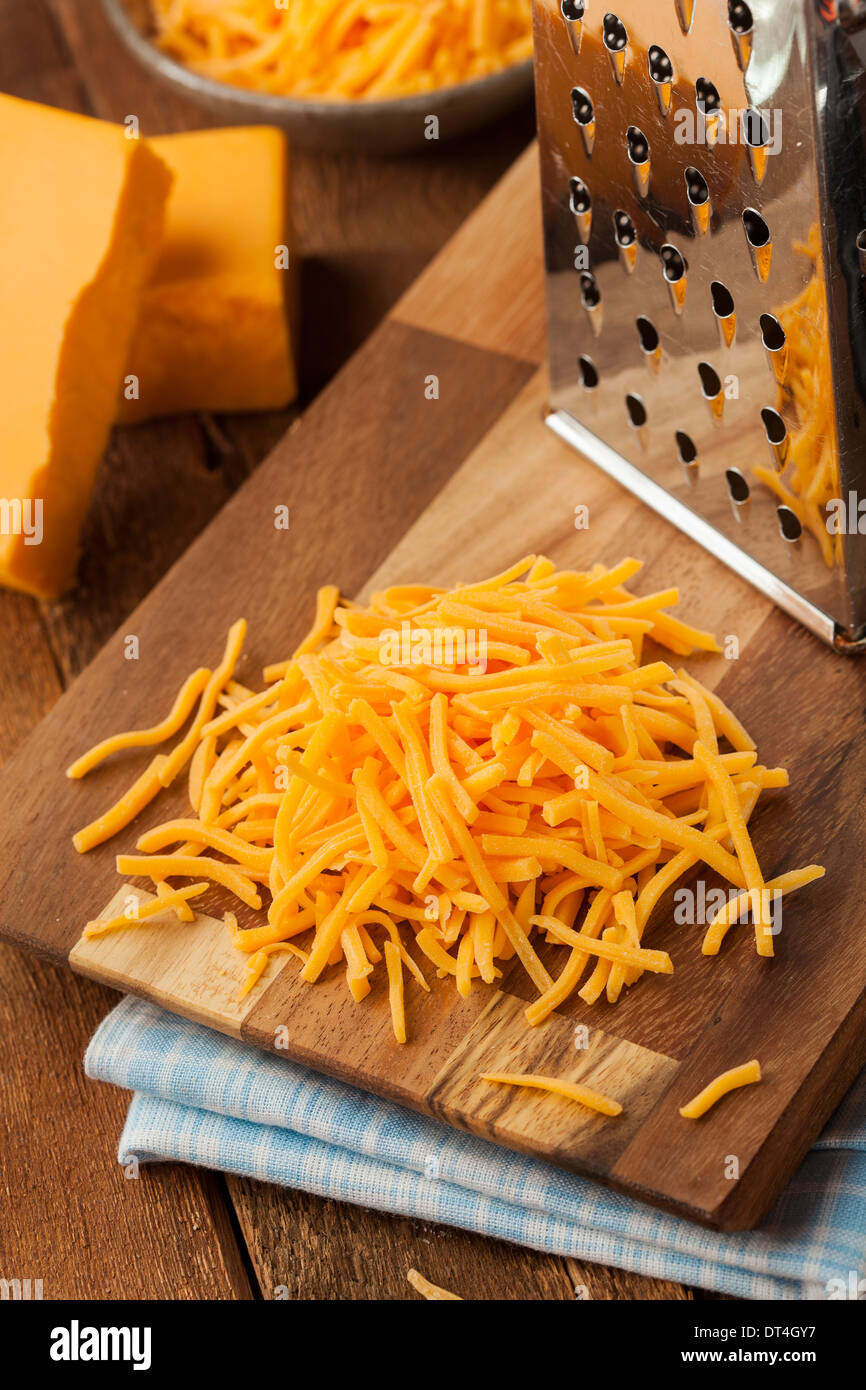 Bio geschreddert scharfe Cheddar-Käse auf ein Schneidebrett Stockfoto