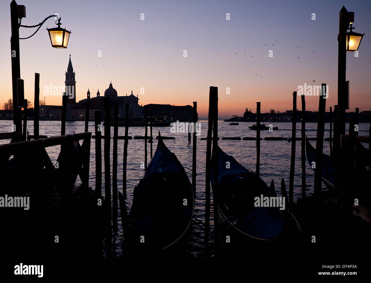 Schwarze Silhouetten der Gondeln am Sonnenaufgang in Venedig Himmel und San Giorgio Maggiore-Hintergrund Stockfoto