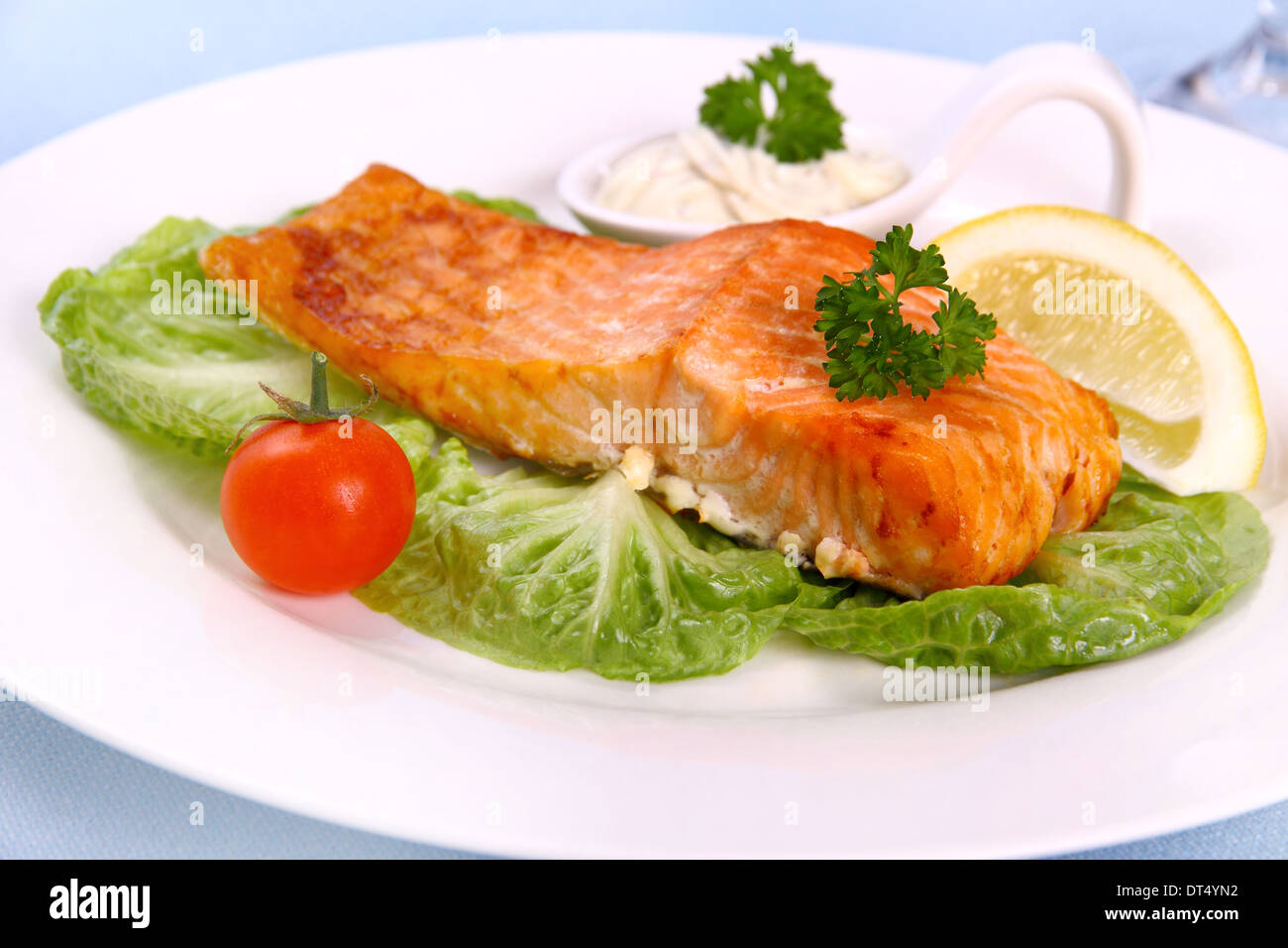 Gegrilltes Lachsfilet mit Salat, Tomate und Zitrone, Nahaufnahme Stockfoto