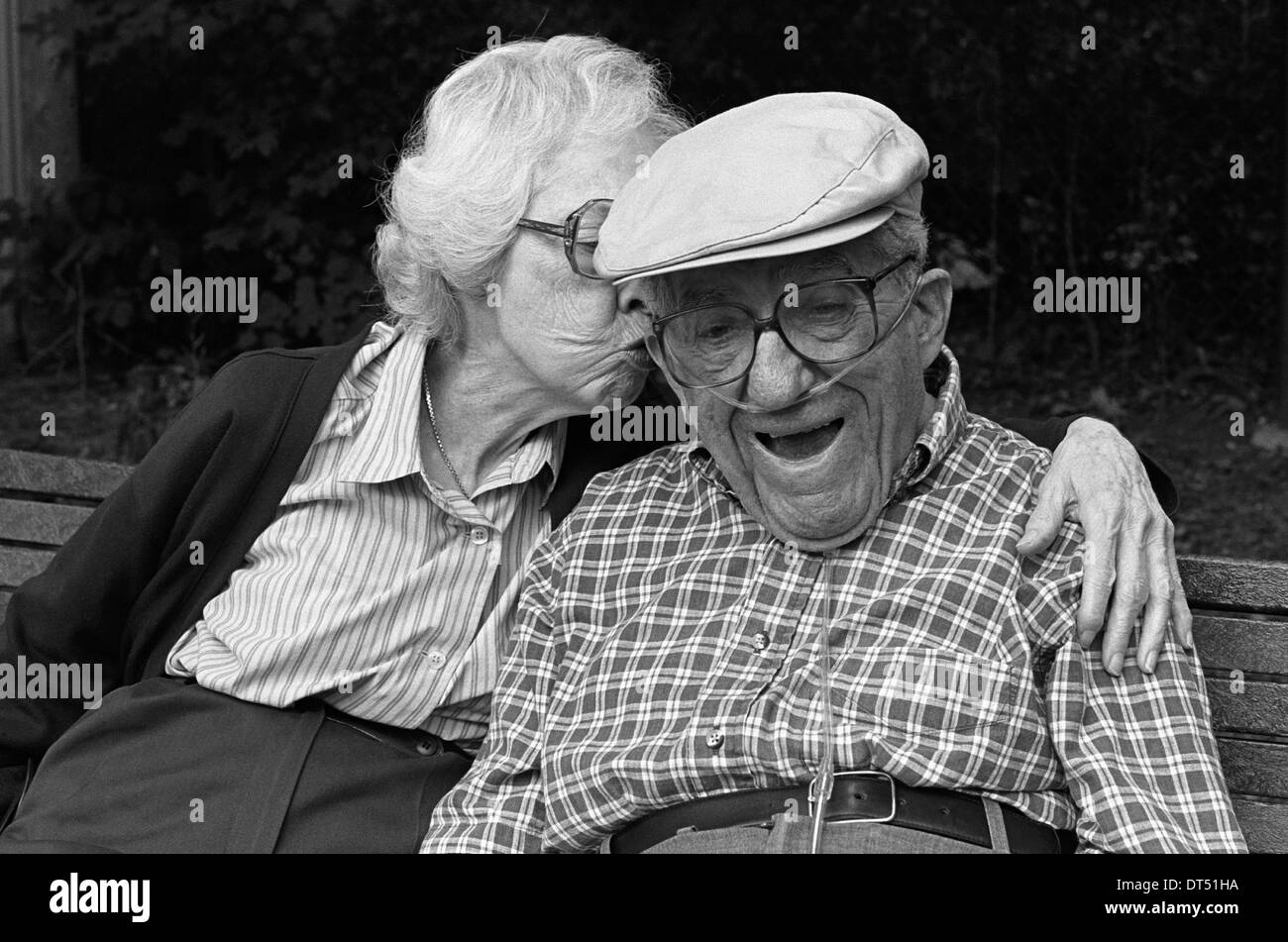 Noch Zuneigung, gibt 85n yr.old Frau einen Kuss zu 90 Jahre alten kranken Mann Ehemann mit Sauerstoff, Stockfoto