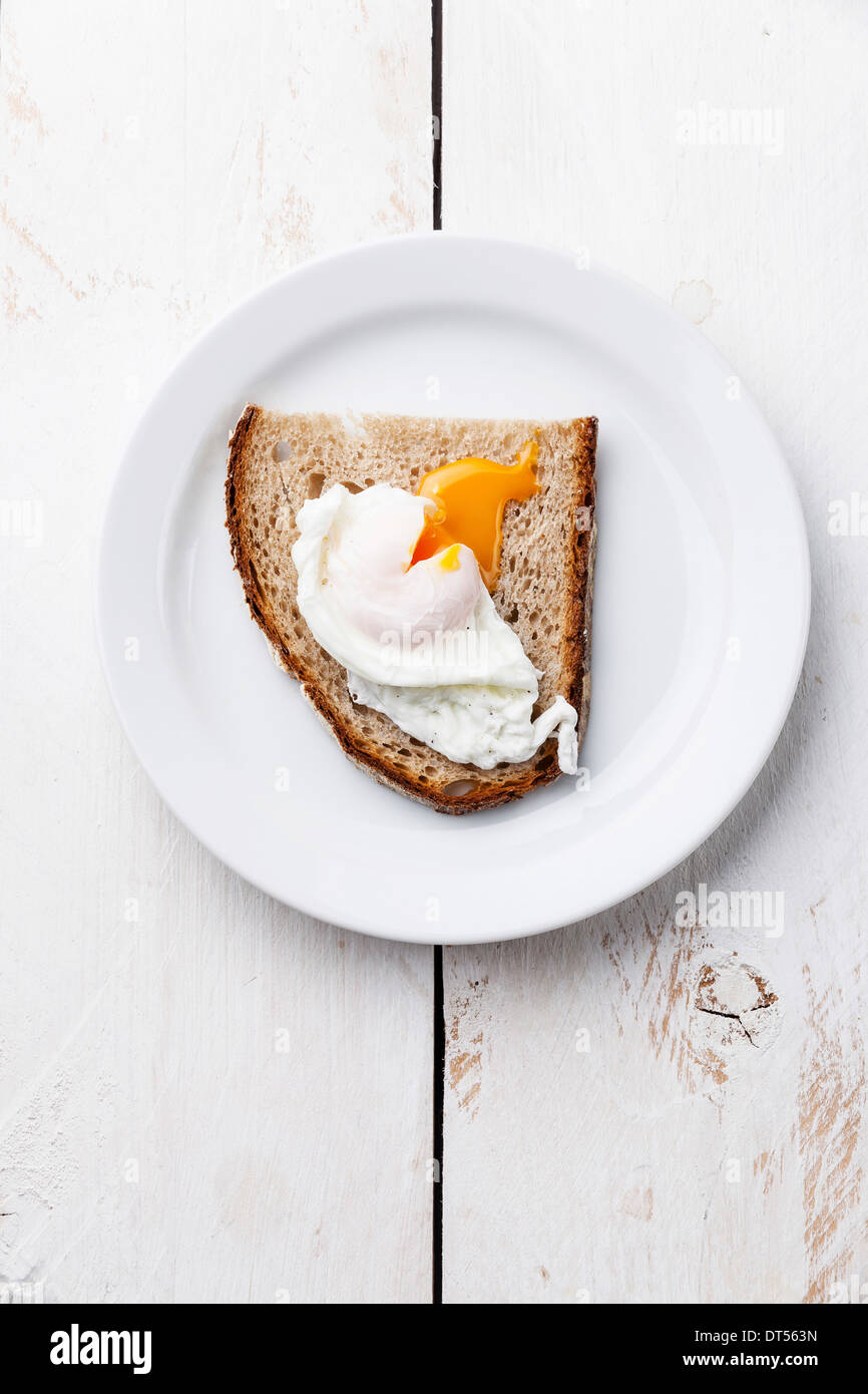 Frühstück mit pochiertem Ei und Brot auf weißem Holz Hintergrund Stockfoto