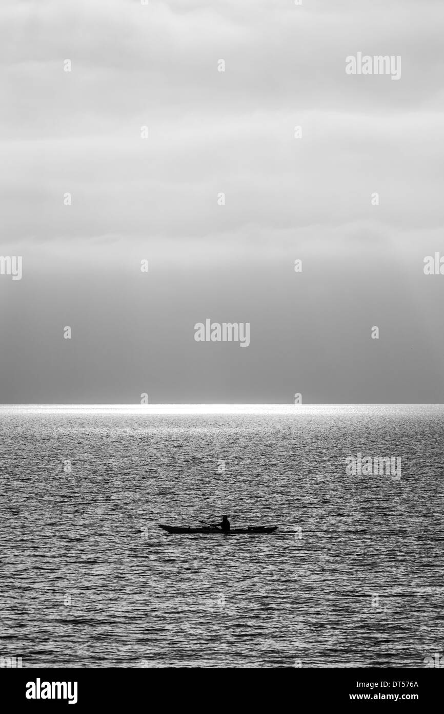Eine einsame Person in einem Kajak auf dem Meer Stockfoto