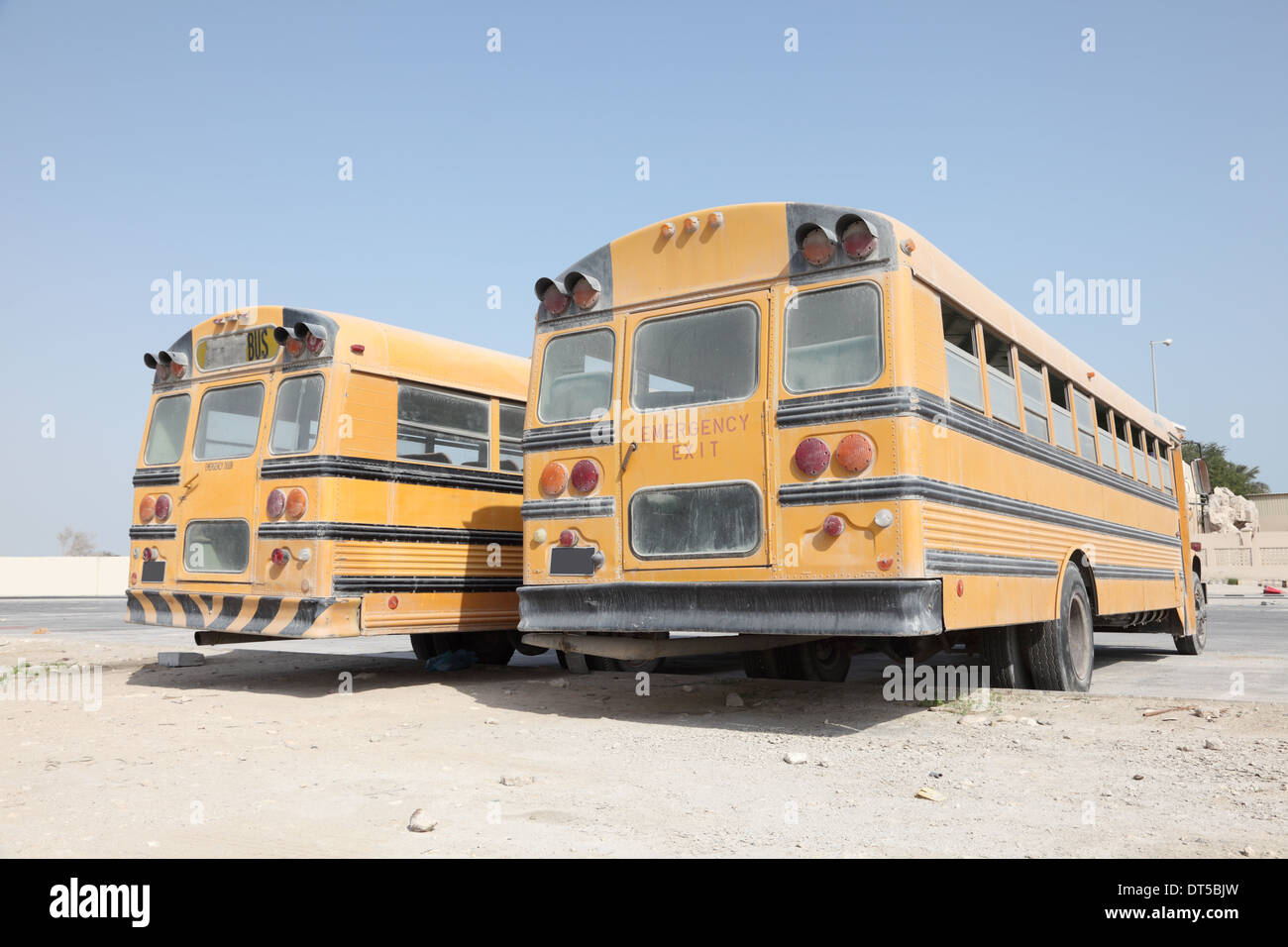 Zwei gelbe Schulbusse auf einem Parkplatz. Doha, Katar, Nahost Stockfoto