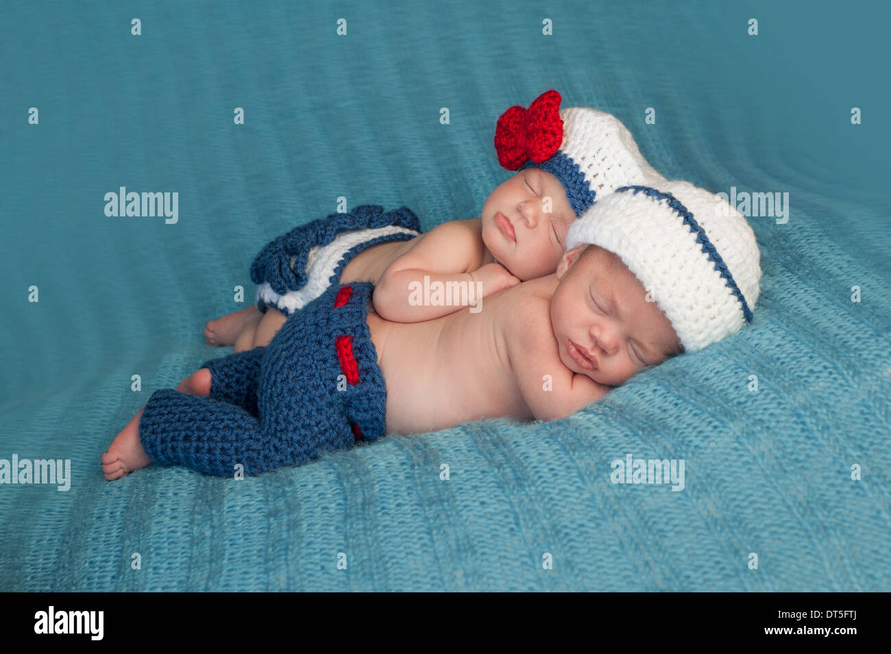 Jungen und Mädchen zwei neugeborene Babys tragen gehäkelte Matrosen-Outfits. Stockfoto