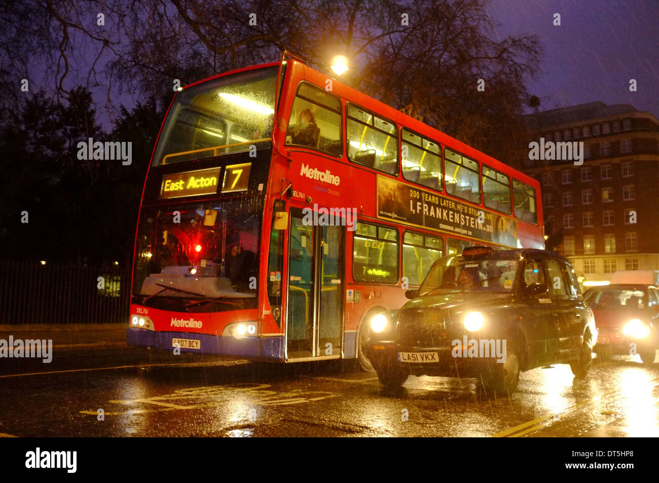 London Bus rot und schwarzes Taxi an einem regnerischen Abend Stockfoto